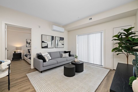 a living room with a couch and a table    and a large window